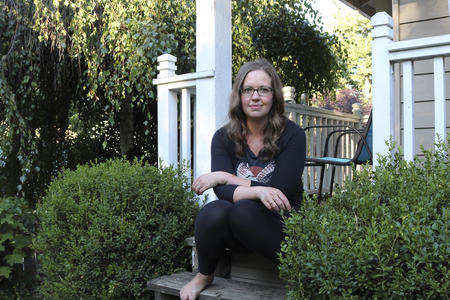 A woman seated on the porch of a house