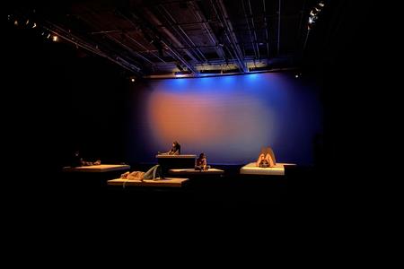 Dark room with a few beds lit by orange and blue light