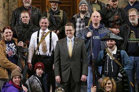 Matt Shea smiles in the House gallery, surrounded by people open carrying firearms