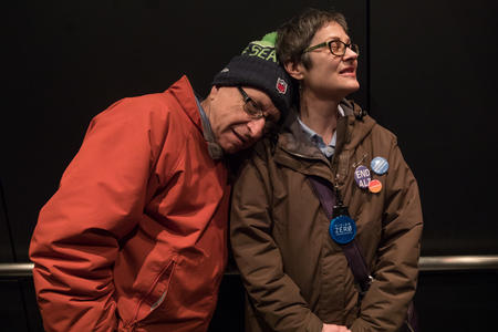 Rafe Schwimmer rests his head on the shoulder of his wife Paula while in an elevator at Seattle City Hall. 