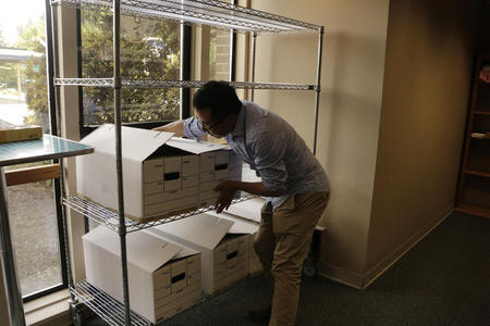 A man stacks boxes on a metal rack