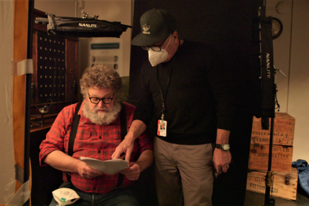 mossback, dressed in flannel, looks over a script