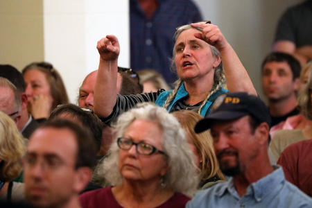 A woman points at Seattle City Council members