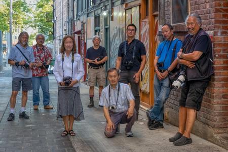 A group of men and women pose for a photo while holding their cameras