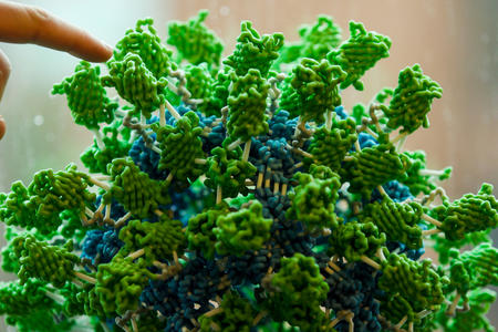 finger pointing at green spikey ball