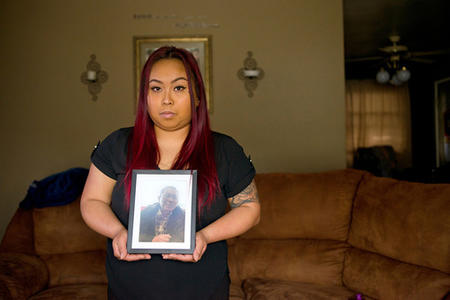 Bopha Khliu holding a picture of her father, Sun Kim Khliu