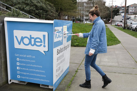 woman drops off her ballot