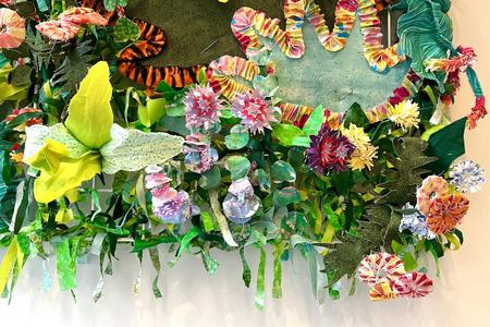 a 3d hanging textile with flowers made from fabric