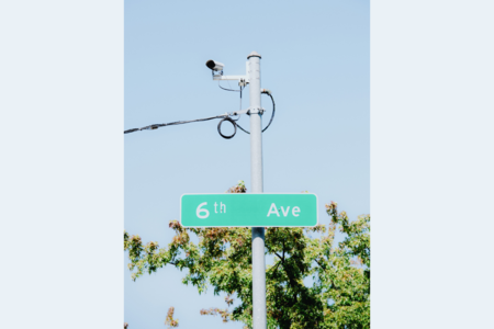 An automatic license plate reader rests on top of a street sign