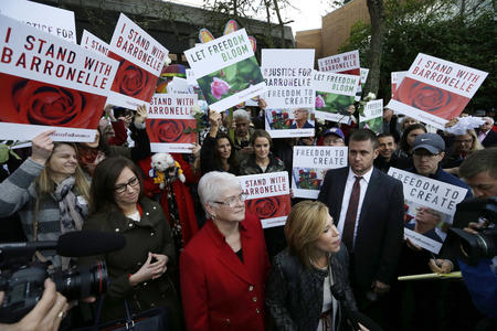 Barronelle Stutzman, center, a Richland, Washington, florist who was fined for denying service to a gay couple in 2013, looks around as she is surrounded by supporters after a hearing before Washington's Supreme Court