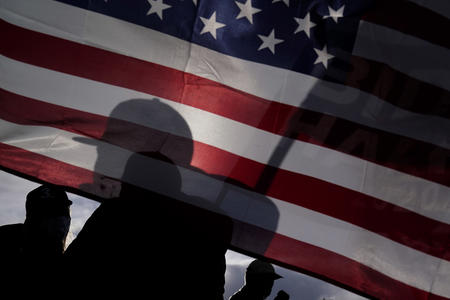 a person standing in front of an American flag