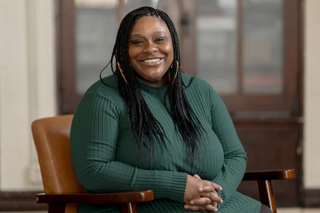 A person sitting in a chair smiles and poses for the camera