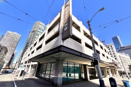 street view of a large white building with a parking garage on top
