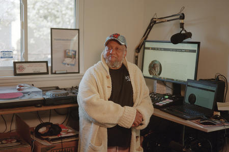 Riz Rollins stands in his home studio for music production and DJ work