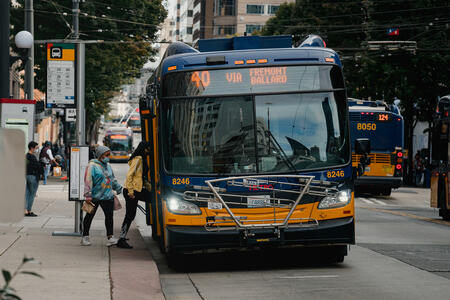 people stand in line boarding a bus in downtown seattle