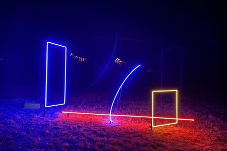 neon shapes in the dark, including a purple vertical rectangle and orange square