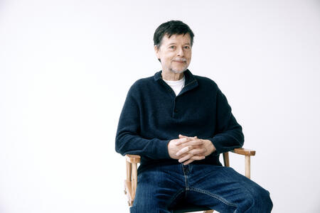 Ken Burns sits on a director's chair