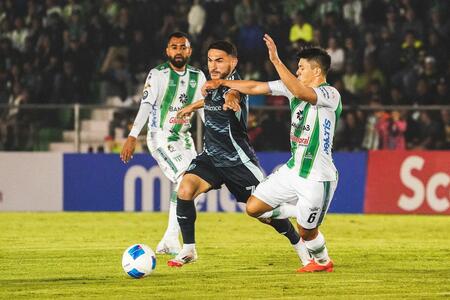 Cristian Roldan dribbles a ball between two opponents