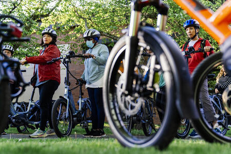 A group of people stand next to their e-bikes at a training in Shoreline.