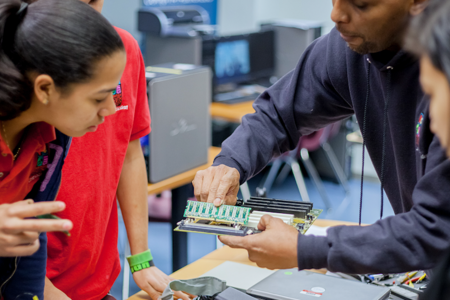 Students gather around a piece of technology