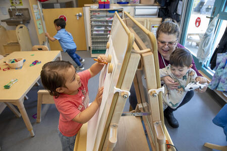 A child draws on a board in preschool.