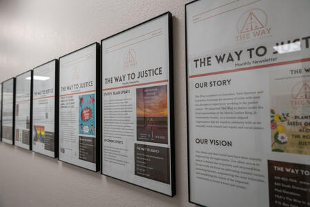 Informational signs about the history of organization The Way To Justice line the walls.