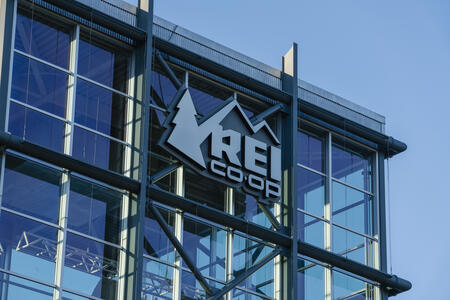 Clear blue skies seen through a glass building with an REI Co-op logo