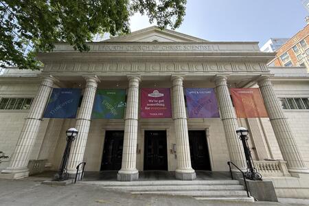photo of a neo-classical white building with columns and colorful banners 