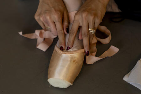 Pacific Northwest Ballet principal dancer Angelica Generosa puts on her pointe shoes during a company class.