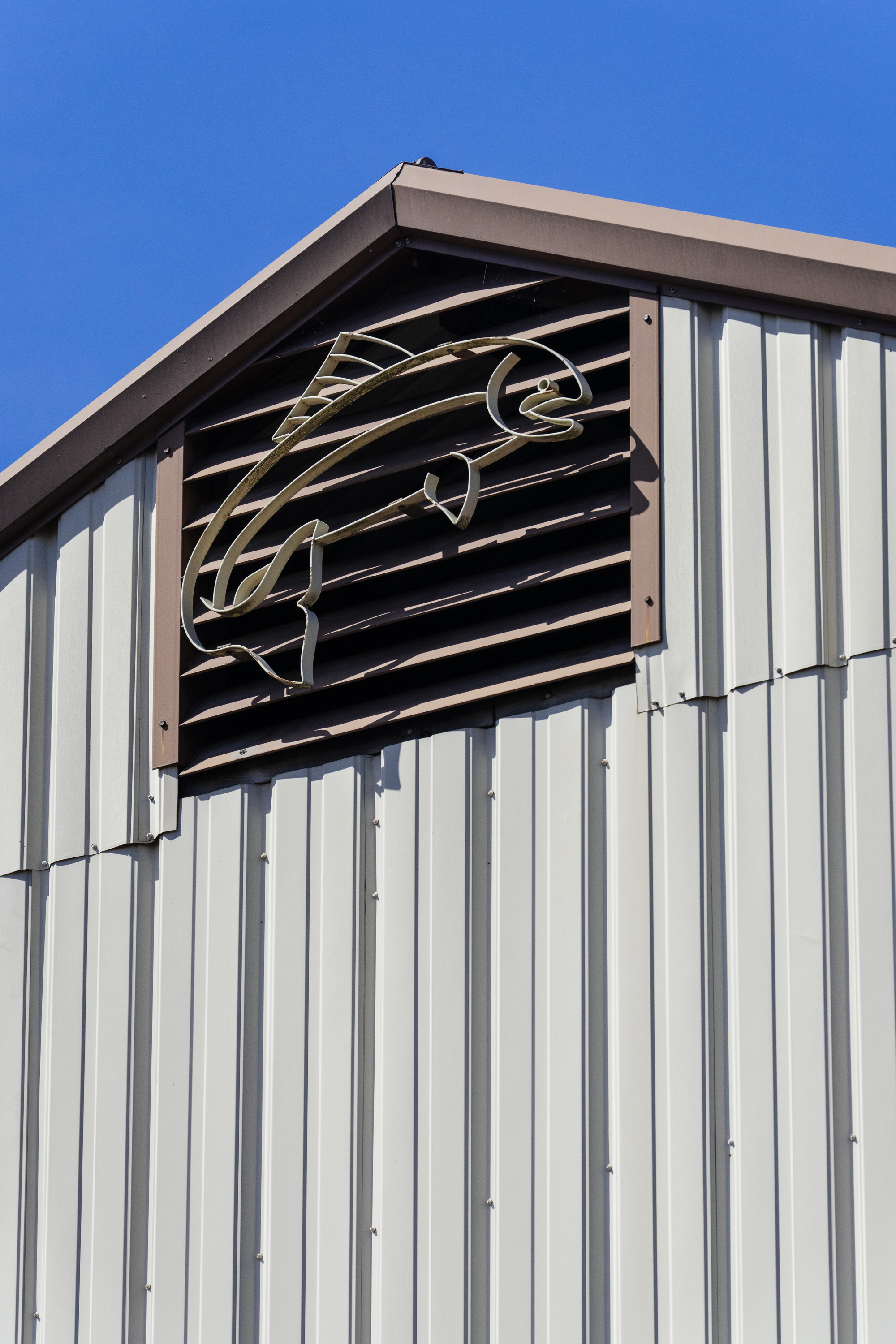A stylized salmon sculpture is seen on a building.